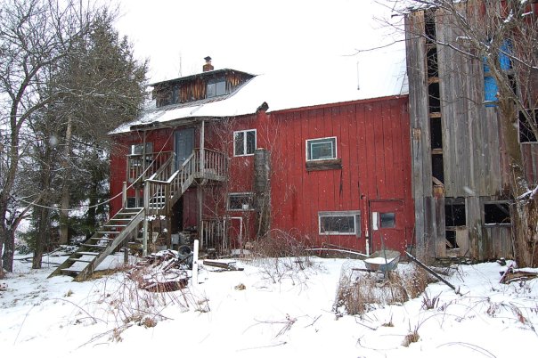 The barn before renovation, full side view with for sale sign in the yard